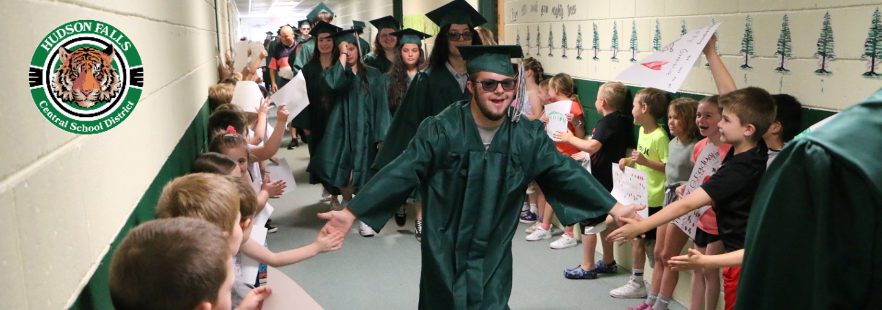 Photo of a graduate giving high fives in the hallway during the class of 2024 building tour