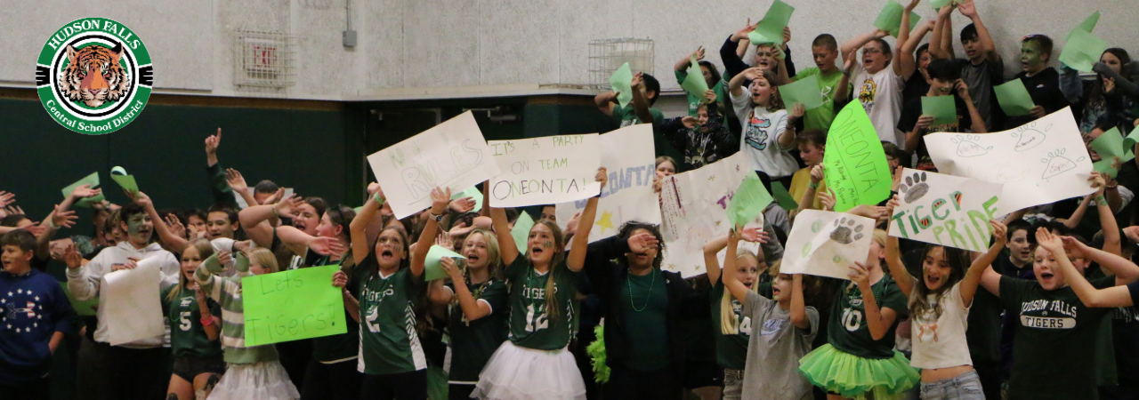 Middle School students holding signs and celebrating at a pep rally