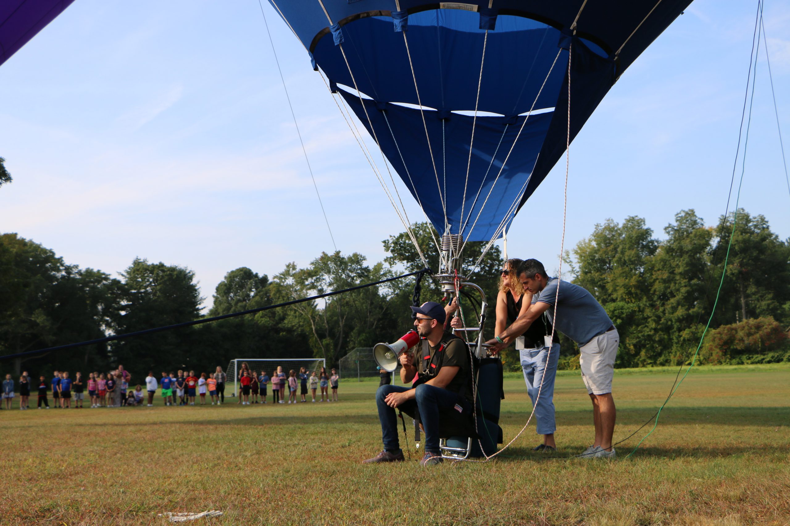 Hot air balloon pilot sitting in single seat talking in megaphone 