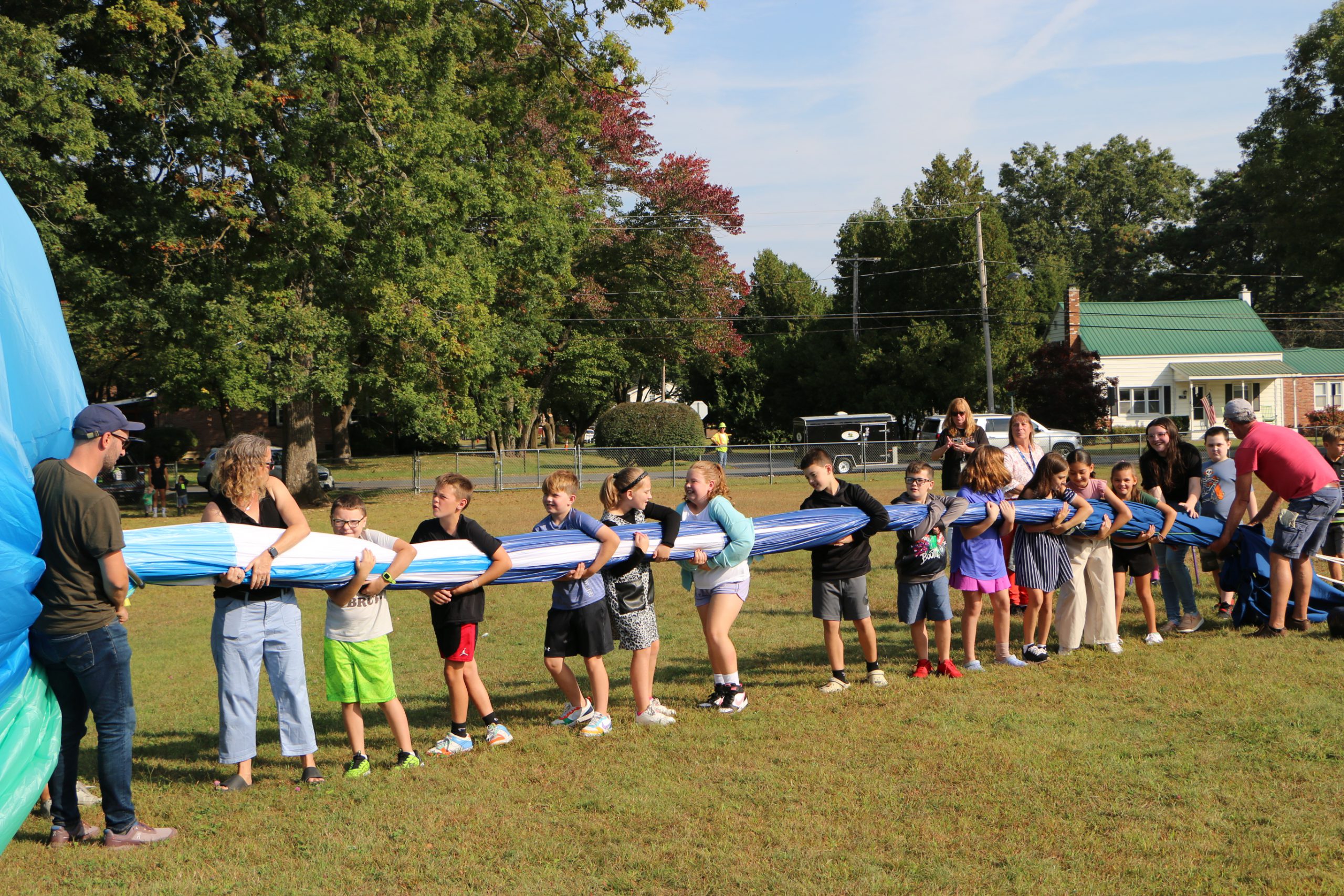 photo of a group of students helping deflate and pack up hot air balloon