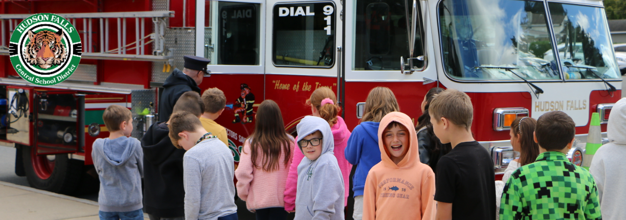 A photo of fifth grade class standing in front of Hudson Falls Red Fire Truck for Fire safety week