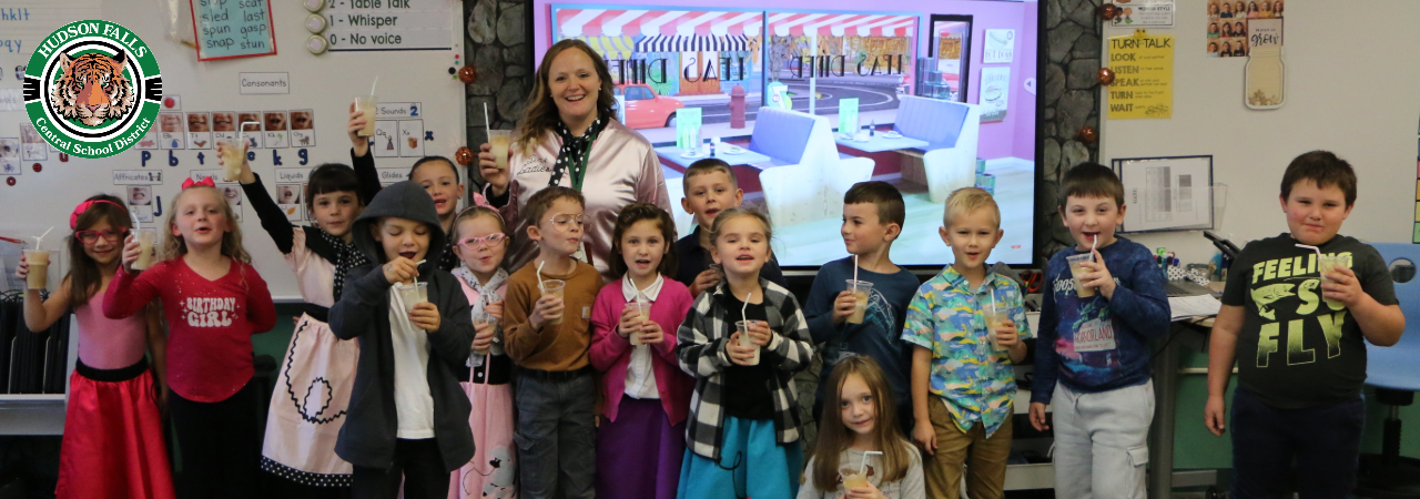 A photo of Mrs. Baulsir's first grade class dressed in 1950's clothing and holding root beer floats