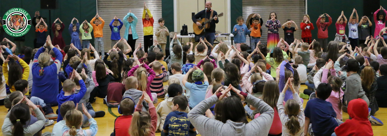 Photo of Primary School students dancing to a man playing guitar